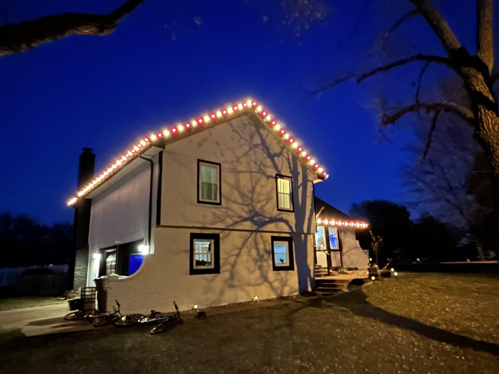 Professional holiday lighting on residential home exterior at night