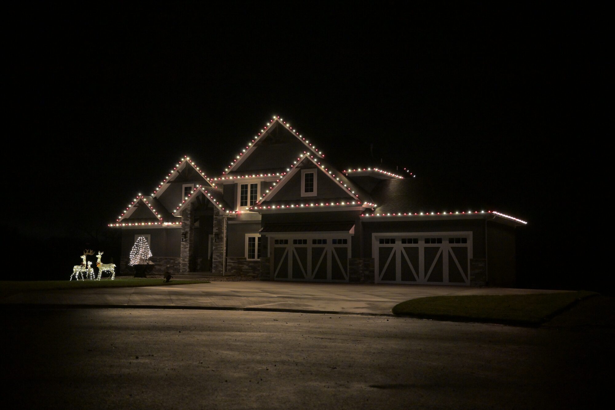 Warm white C9 Christmas lights on modern home roofline — Reign Enterprises