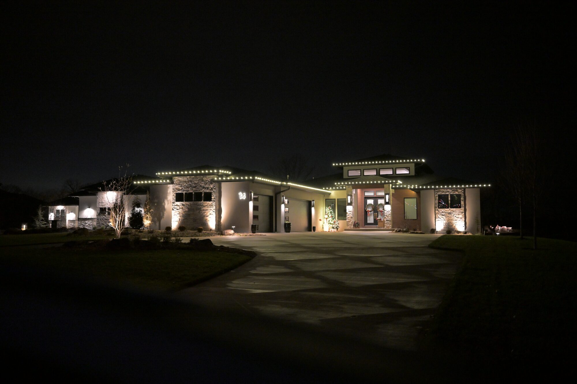 Warm white C9 LED lights on modern luxury home roofline — Reign Enterprises